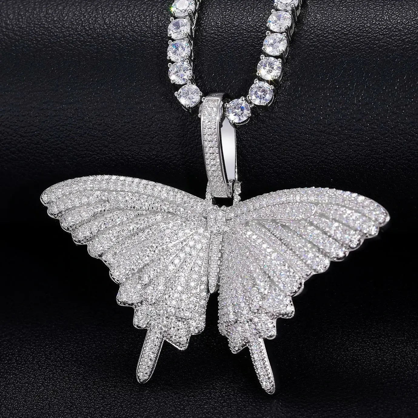 Front view: S925 butterfly pendant with tennis chain on black table - full pavé moissanite wings sparkling brighter than diamonds | Men's luxury nature-inspired jewelry