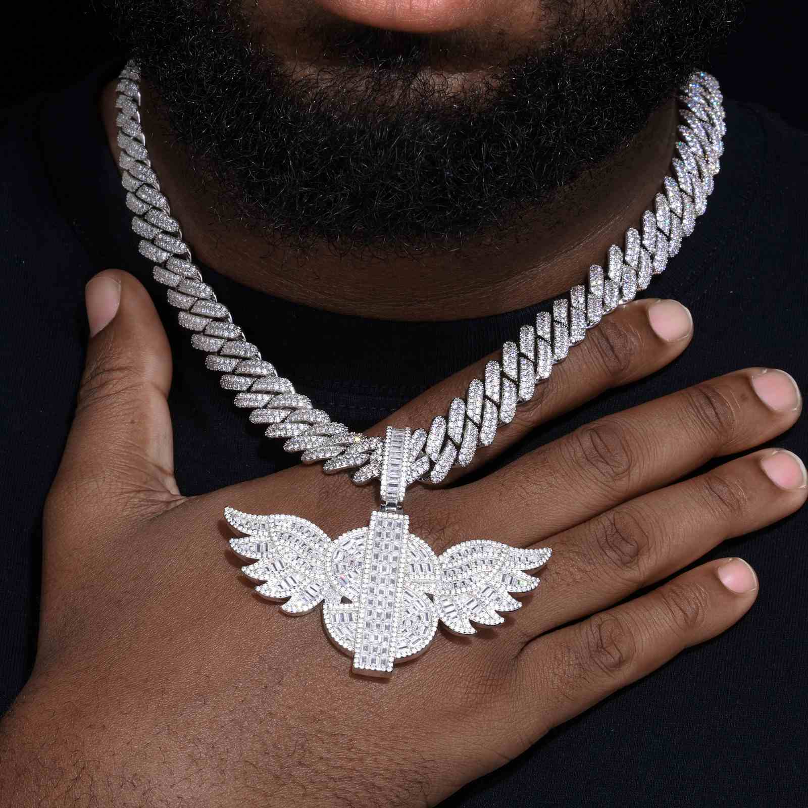 Tattoo artist in studio wearing dollar wing pendant necklace, blending streetwear jewelry with urban creative culture