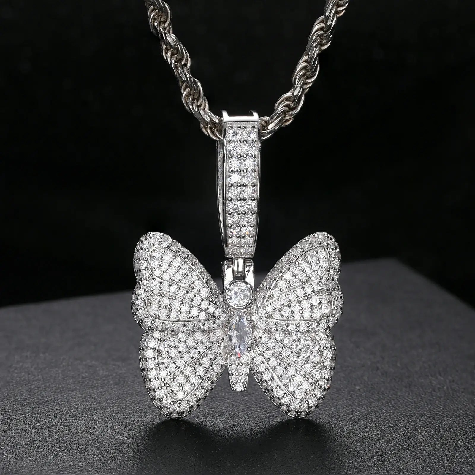 Front view: White gold butterfly pendant on rope chain against black - moissanite wings sparkling brighter than diamonds | Men's luxury nature jewelry