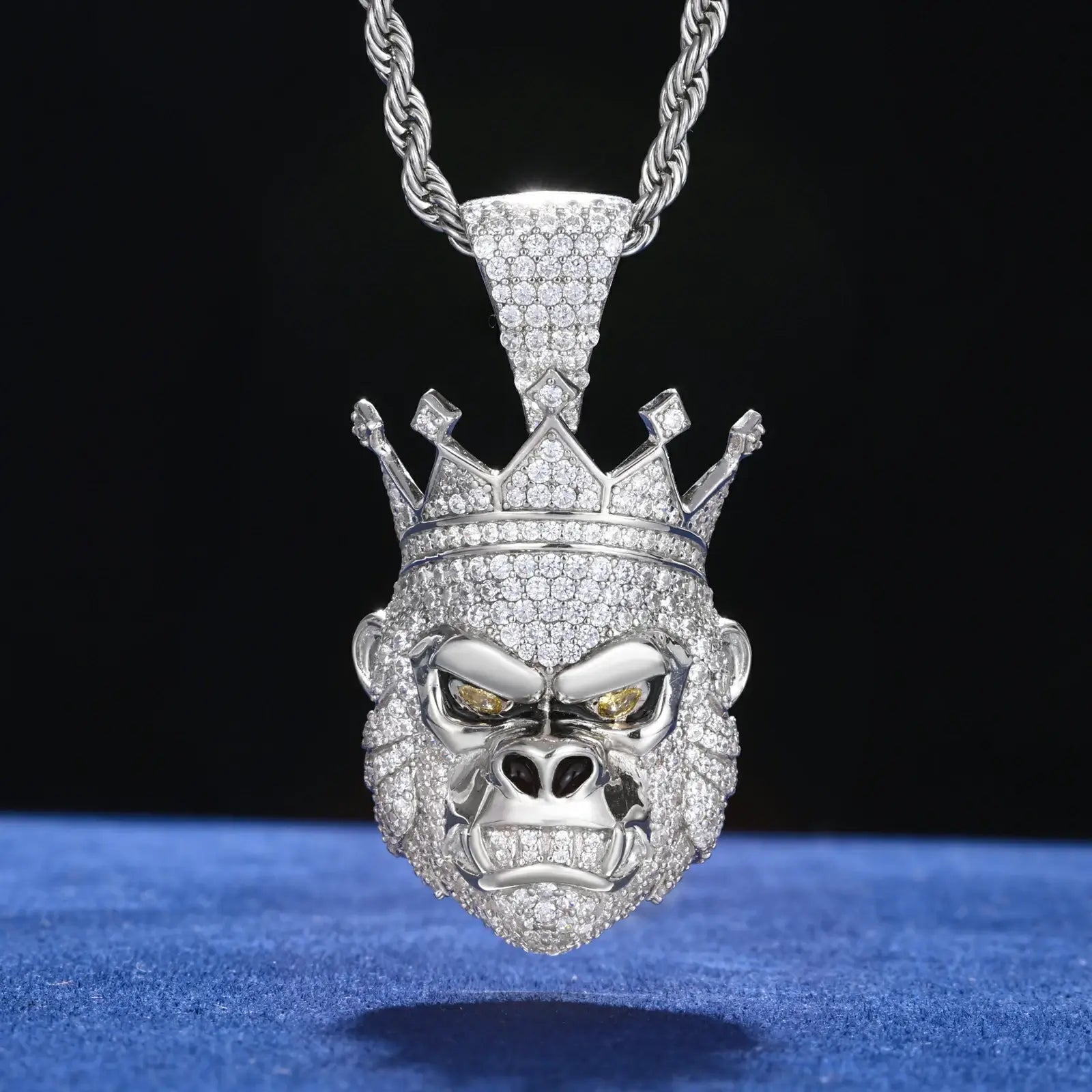White gold gorilla king pendant hanging on blue table - 925 sterling silver with full moissanite pave and detailed animal design