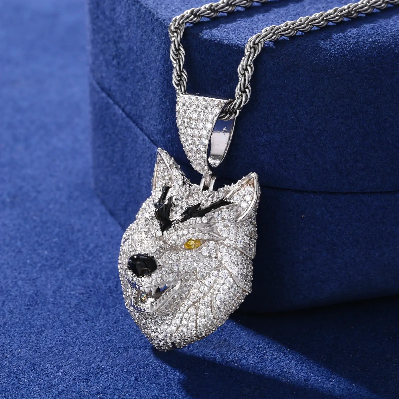 Side view of white gold wolf pendant on blue table - showing 3D construction and detailed moissanite pave setting